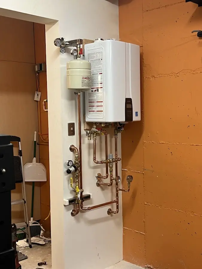 Plumbing technician inspecting water heater connections in Kingwood